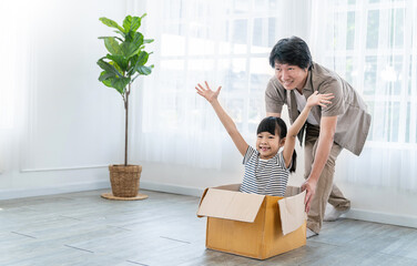 Asian single dad family father daughter girl packing cardboard box moving, online marketing e-commerce unpacking stuff belongings home delivery. Lifestyle happy white family together relocation