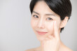 美容などに使いやすい睫毛や目元を指さすアジア系（日本人）女性のアップ　カメラ目線