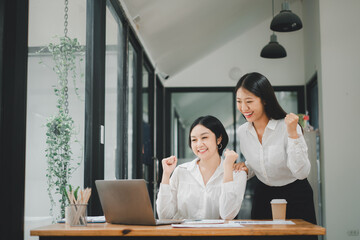 Beautiful two asian girl celebrate with laptop, success happy pose, E-commerce, university education, internet technology, or startup small business concept.