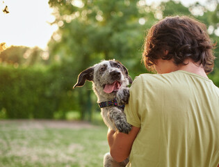 outdoor portrait of boy with his adopted dog. friendship of teenager with pet, boy walking in summer