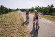 two sisters ride a bike, orchard cherry orchard, country life