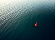 Orange buoy floating in rippling sea