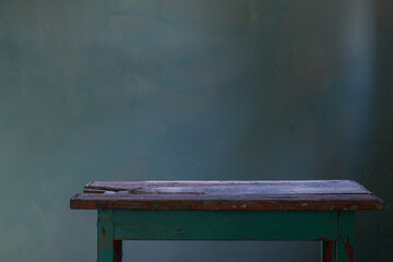 Wall Mural - old wooden table on background green old wall