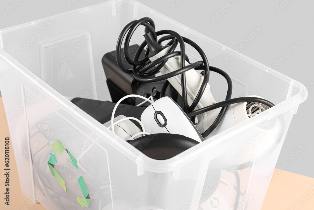 Recycle bin with different household appliances on color background