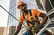 © Denis Yevtekhov - A portrait of a construction worker wearing a safety harness, scaling the exterior of a tall building during construction Generative AI