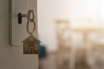 Open door to a new home with key and home shaped keychain. Mortgage, investment, real estate, property and new home concept