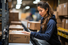 Employees Work To Sort Cardboard Boxes Before Shipping. At Warehouse. A Woman Working In A Factory Warehouse Scanning Labels On Boxes With A Barcode Scanner.