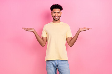 Poster - Photo portrait of young multiethnic guy hold open palms novelty products advise wear shirt jeans isolated pink color background