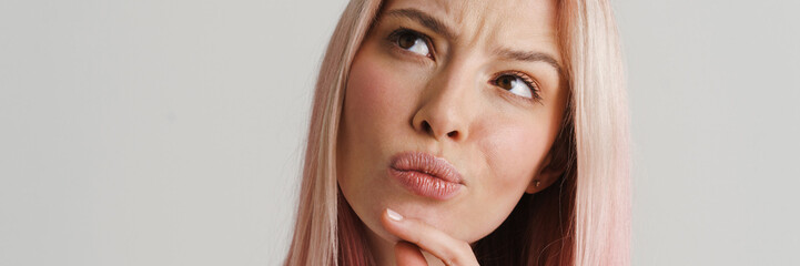 Wall Mural - Close up of a pensive young woman over gray