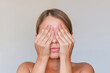 © Марина Демешко - Young caucasian blonde woman closes her eyes covering them with hands isolated on gray background. Pain in the eyes, photophobia, painful sensitivity to bright light. Surprise, hiding. Ophthalmology