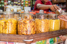 Assortment Of Dried Fruits Laid Out In Glass Jars, Sold At Goa Market. Salesman Merchandise Indian Food In Small Store.