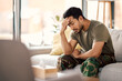 © Daniels C/peopleimages.com - Man with headache, stress and mental health problem, therapy and psychology, depressed and sitting on couch. Male person in crisis, migraine and medical issue, sad with depression and pain at home