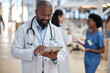 © Tshidzumba/peopleimages.com - Doctor, black man and tablet for medical planning, data research or healthcare app in busy hospital. Happy male surgeon, digital technology and consulting information on telehealth schedule in clinic