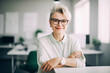 © ximich_natali - Beautiful middle-aged financial business woman executive, wearing glasses, with gray hair, looks at the camera and smiles