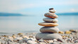 Balanced pebble pyramid silhouette on the beach with the ocean in the background. Zen stones on the sea beach, meditation, spa, harmony, calmness, balance concept