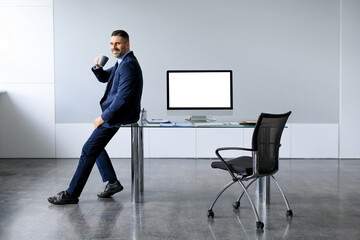 Poster - Business mock up template. Cheerful middle aged man sitting on desk with blank computer screen, free space