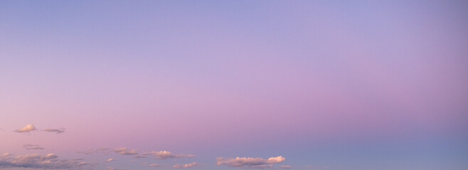 pink and blue sky with sparse clouds at sunrise or sunset shot at 24 mm focal length