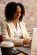 © wavebreak3 - Happy african american casual businesswoman using laptop in office