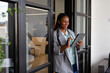 Happy plus size african american casual businesswoman using tablet in office window