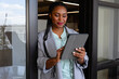 Plus size african american casual businesswoman using tablet in office window