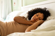© WavebreakMediaMicro - Biracial woman taking nap on bed in bedroom
