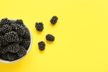 Wall Mural - Bowl with fresh blackberry on yellow background, closeup