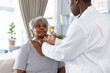 © Wavebreak Media - African american female doctor examining senior female patient, touching neck at hospital