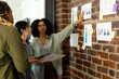 © Wavebreak Media - Diverse fashion designers using tablet and discussing design drawings on wall at studio