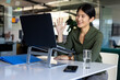 © Wavebreak Media - Happy asian casual businesswoman at desk in office having video call on laptop, waving
