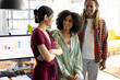 © Wavebreak Media - Three happy diverse casual business colleagues standing in sunny office talking