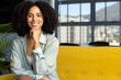 © Wavebreak Media - Portrait of smiling biracial casual businesswoman with curly dark hair on sofa in office, copy space