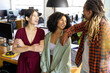 © Wavebreak Media - Three happy diverse casual business colleagues standing in sunny office relaxing and talking