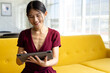 © Wavebreak Media - Happy asian casual businesswoman using tablet sitting on sofa in office, copy space