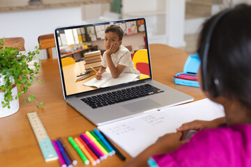Poster - Multiracial girl discussing homework with boy over laptop while studying online on table at home