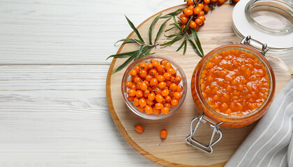 Wall Mural - Delicious sea buckthorn jam and fresh berries on white wooden table, flat lay. Space for text