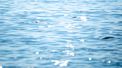 Wall Mural - sun light reflecting or sparkling glitter on water of sea or ocean with beautiful sky blue light ton