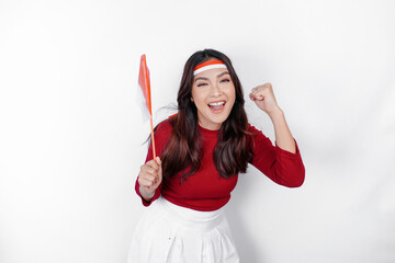 Excited young Asian woman celebrate Indonesian independence day holding the Indonesian flag isolated on white background