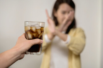 Dieting or good health concept. Young woman rejecting Junk food or unhealthy food such as sweet soda drink and choosing healthy food such as fresh fruit or vegetable.