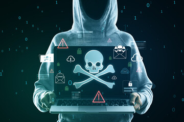 Wall Mural - Hacker holding laptop with glowing skull hologram on blurry background. Hacking, malware and phishing concept.