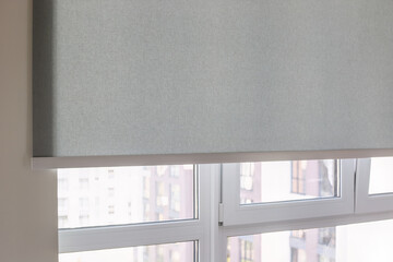 Leinwandbilder - Roller blinds automatic close-up on the window. Selective focus. Motorized shades. Gray color curtain, texture fabric. City outside the window.