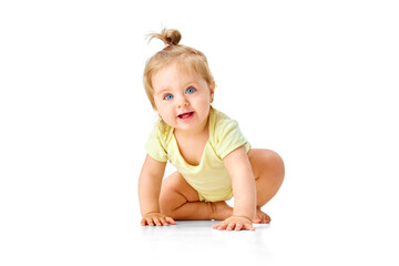 curious little baby girl, toddler crawling forward and attentively looking with interest against whi