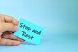 © sulit.photos - Stop and rest reminder concept. Hand holding a bright green paper message note.