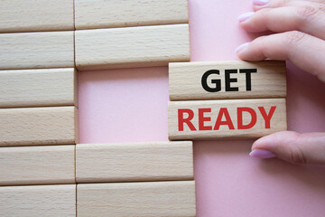 Wall Mural - get ready symbol. wooden blocks with words get ready. beautiful pink background. businessman hand. b