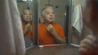 © Marco - Senior man grooming himself in front of mirror during morning ritual. Domestic lifestyle of older person in 70s getting ready inspecting face and skin