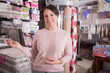 © caftor - woman seller welcomes visitors to the bedding shop