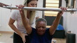 Female Pilates Coach assisting a black senior woman to use machine, old age workout routine, flexibility and strengthening body