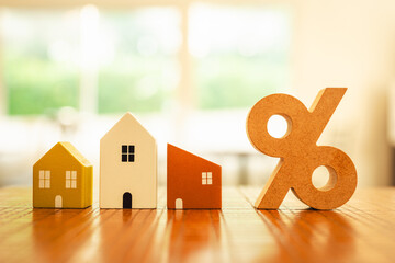 Percentage and house sign symbol icon wooden on wood table. Concepts of home interest, real estate, investing in inflationม home loan interest rate hike.	
