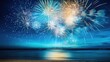 © All Creative Lines - Blue, gold, white fireworks above water with reflection on the black sky background. New Year, wedding beach celebration. American holiday.