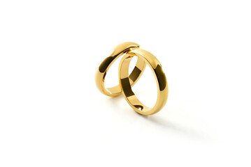 Engagement gold rings leaning on each other on white background