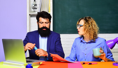 Wall Mural - Students studying in university. Male teacher and female student in classroom. Male and female teachers working with laptop in auditorium. Female student at exam in classroom. Tutoring and education.